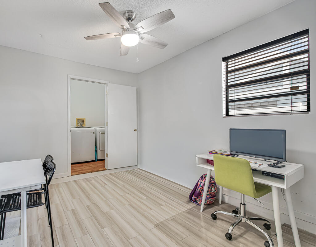 23428 Country Club Drive East Boca Raton, FL 33428 - Photo 24 of 32 a bedroom with a bed and a chair