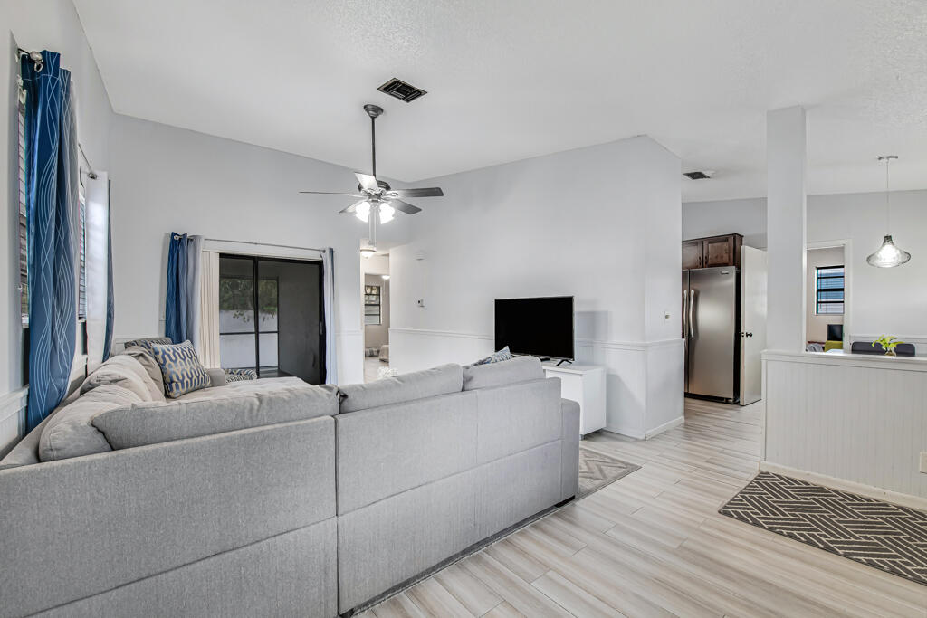23428 Country Club Drive East Boca Raton, FL 33428 - Photo 9 of 32 a living room with furniture and a flat screen tv