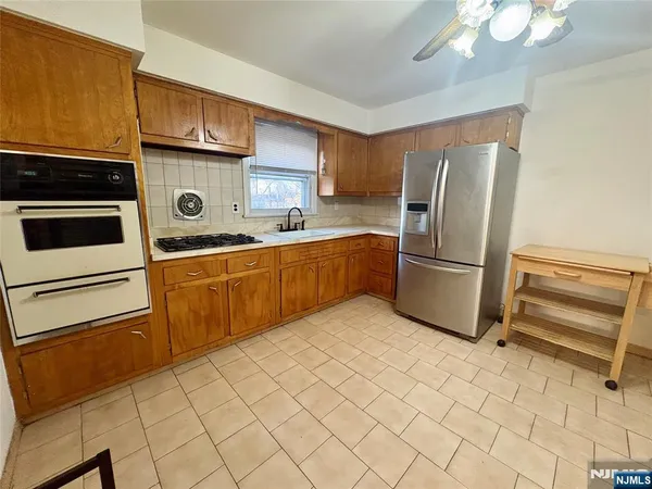 a kitchen with a refrigerator sink and cabinets