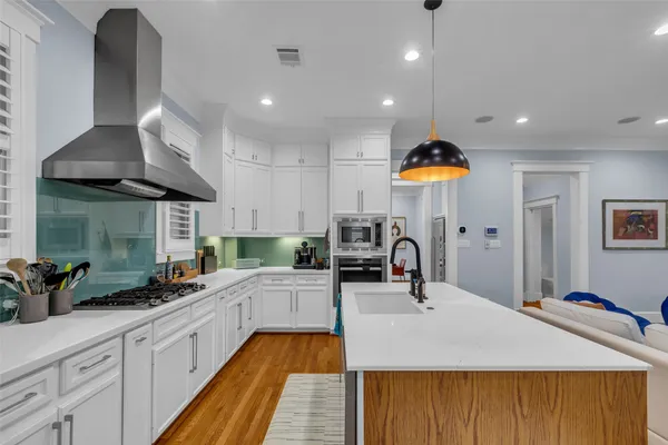 a kitchen with stainless steel appliances kitchen island granite countertop a sink a stove and cabinets