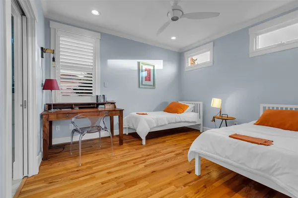 a bedroom with two beds and a desk