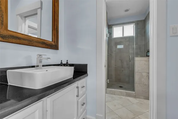 a bathroom with a sink and a mirror with bathtub