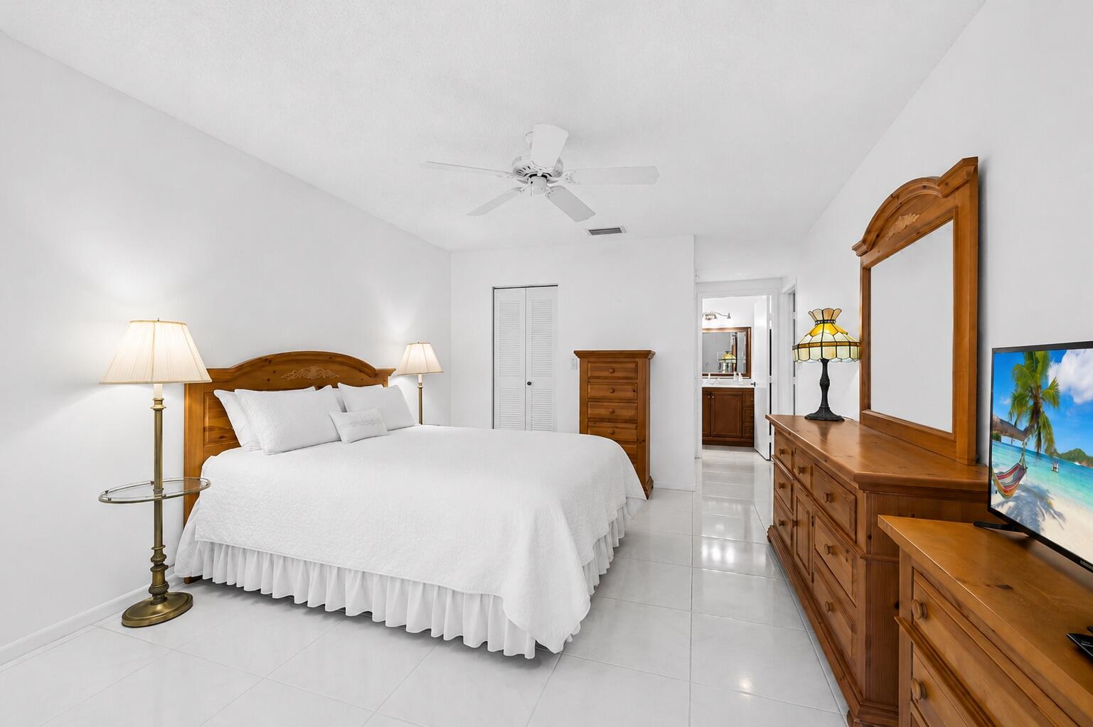 18762 Candlewick Drive Boca Raton, FL 33496 - Photo 15 of 52 a spacious bedroom with a bed and a flat tv screen on dresser