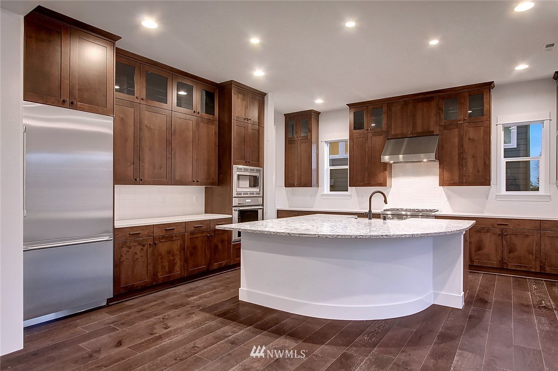 21638 35th Avenue Southeast, Unit 21 Bothell, WA 98021 - Photo 5 of 25 a large kitchen with kitchen island a large counter top and stainless steel appliances