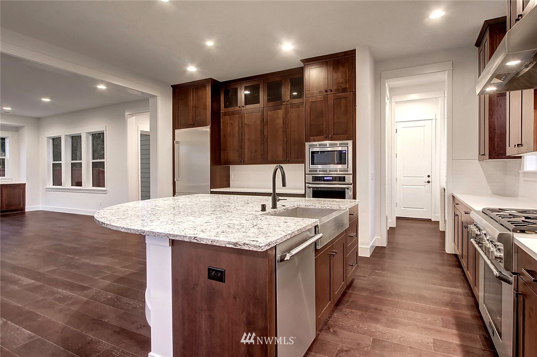 21638 35th Avenue Southeast, Unit 21 Bothell, WA 98021 - Photo 7 of 25 a kitchen with stainless steel appliances granite countertop a kitchen island a stove and a sink
