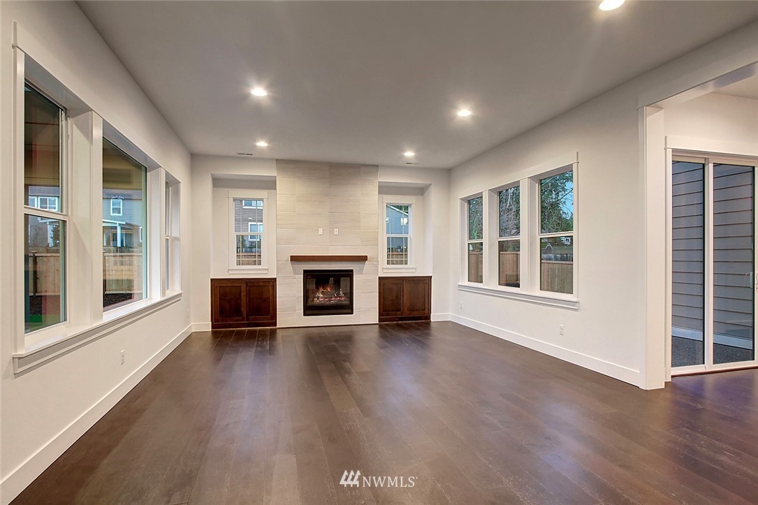 21638 35th Avenue Southeast, Unit 21 Bothell, WA 98021 - Photo 8 of 25 an empty room with wooden floor and fireplace