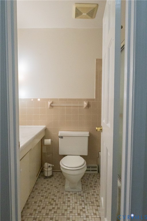 309 Old Plank Road Kenbridge, VA 23944 - Photo 38 of 45 White toilet, tan wall tiling, mosaic floor tiling