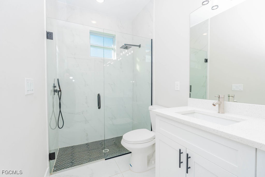 4419 22nd Street Southwest Lehigh Acres, FL 33973 - Photo 12 of 31 a bathroom with a sink a toilet and shower