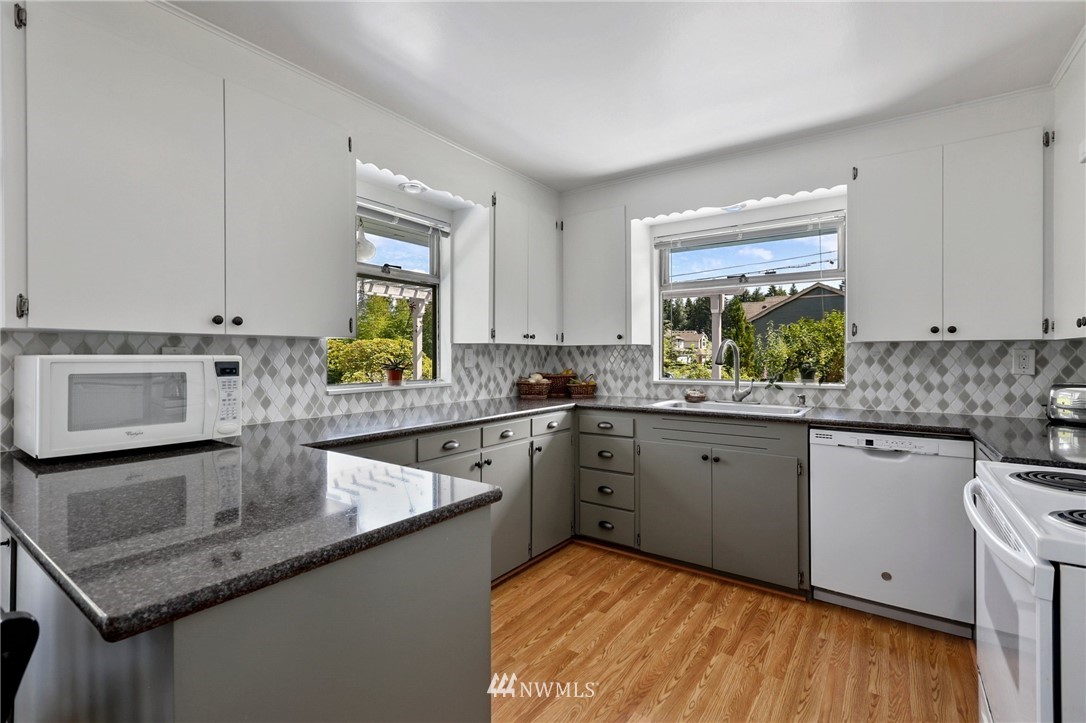 717 224th Street Southwest Bothell, WA 98021 - Photo 13 of 40 a kitchen with stainless steel appliances granite countertop a sink stove and cabinets