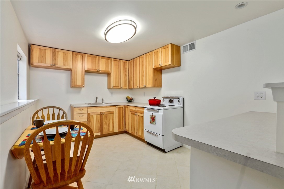 717 224th Street Southwest Bothell, WA 98021 - Photo 24 of 40 a kitchen with stainless steel appliances a stove a sink cabinets and a window