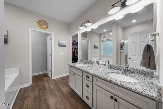 a bathroom with a granite countertop tub sink and mirror