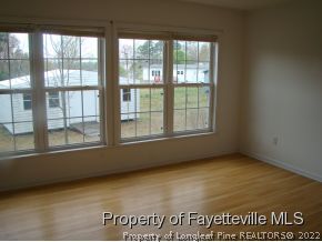 261 Lee Thee Church Road Rockingham, NC 28379 - Photo 4 of 9 an empty room with wooden floor and windows