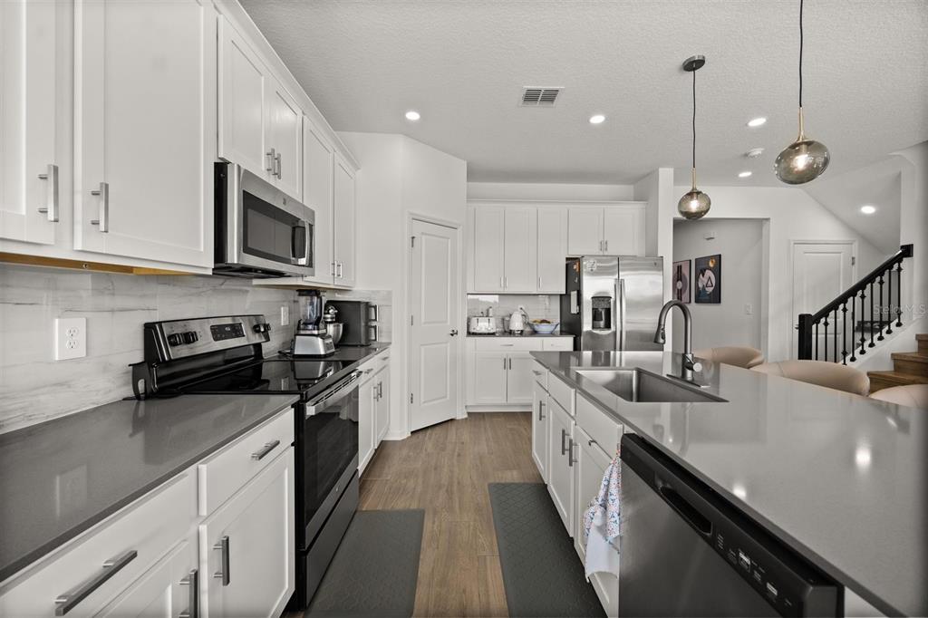 11163 Great Rock Street Winter Garden, FL 34787 - Photo 11 of 36 a large kitchen with stainless steel appliances lots of counter space sink and cabinets