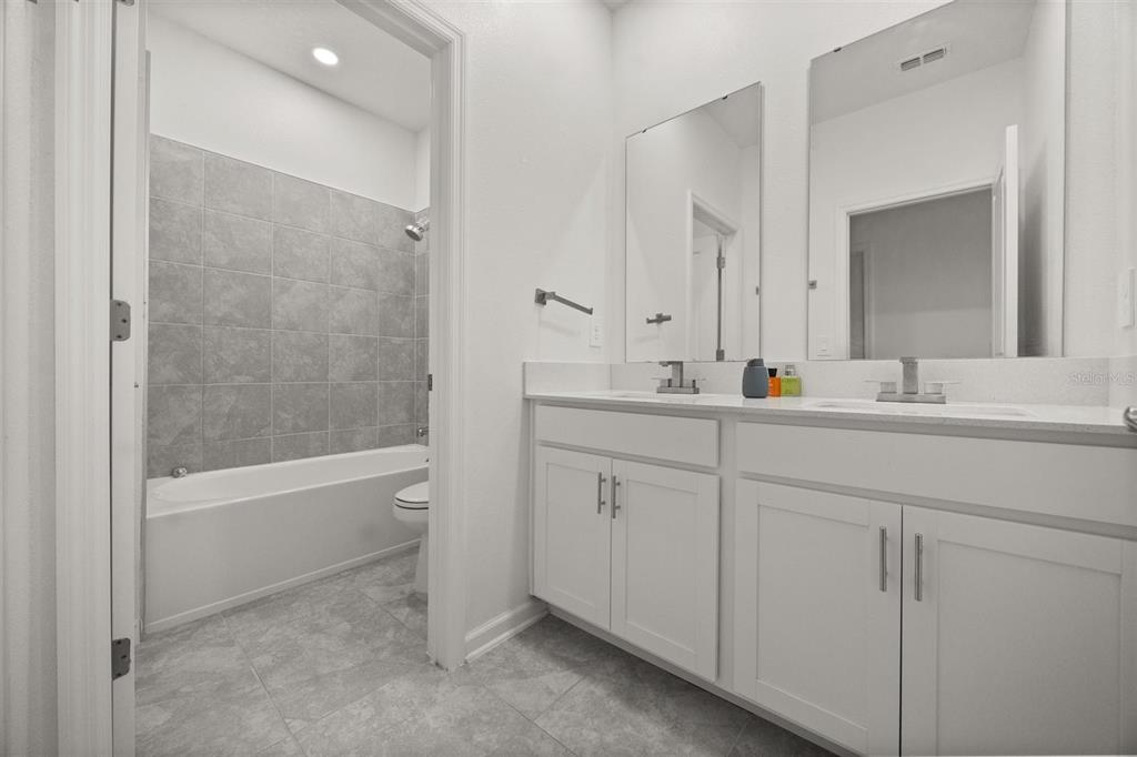 11163 Great Rock Street Winter Garden, FL 34787 - Photo 28 of 36 a bathroom with a bathtub sink vanity and mirror