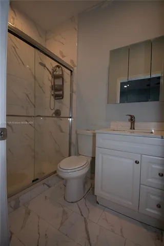 a bathroom with a shower sink and mirror