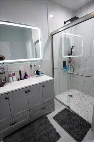 a bathroom with a sink and mirror with toilet