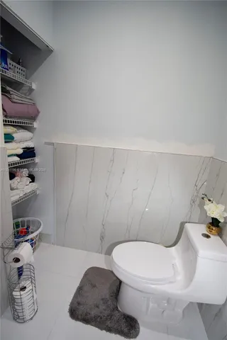 a room with kitchen island stainless steel appliances a sink a counter top space cabinets and stainless steel appliances