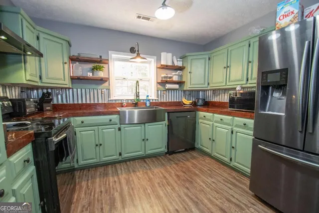 a kitchen with granite countertop a refrigerator and a sink