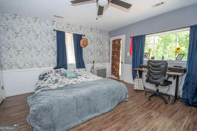 a spacious bedroom with a bed and a dresser