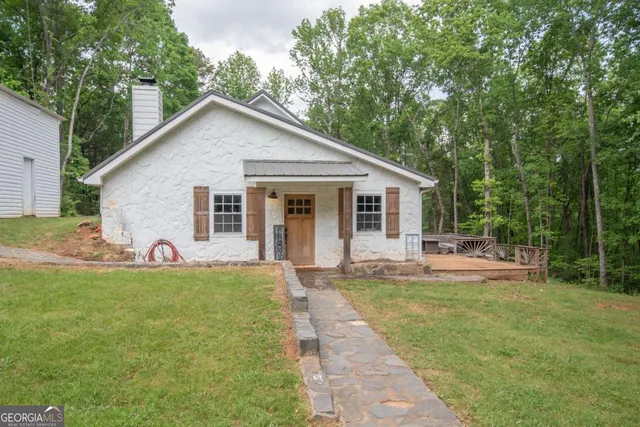 a view of a house with a yard and sitting area