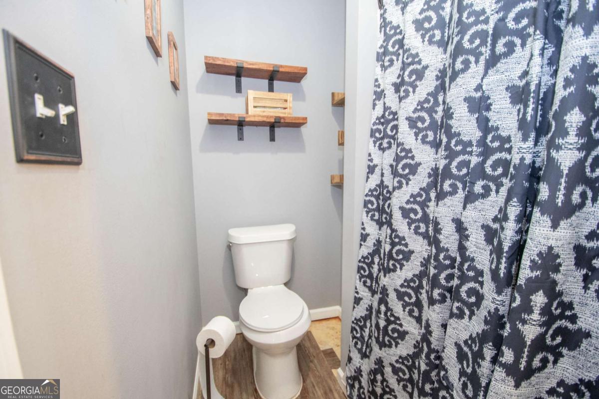 3414 Rock Mills Road LaGrange, GA 30240 - Photo 25 of 54 a white toilet sitting next to a shower curtain