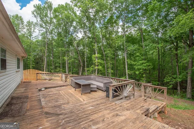 a view of a swimming pool with an outdoor seating and a forest