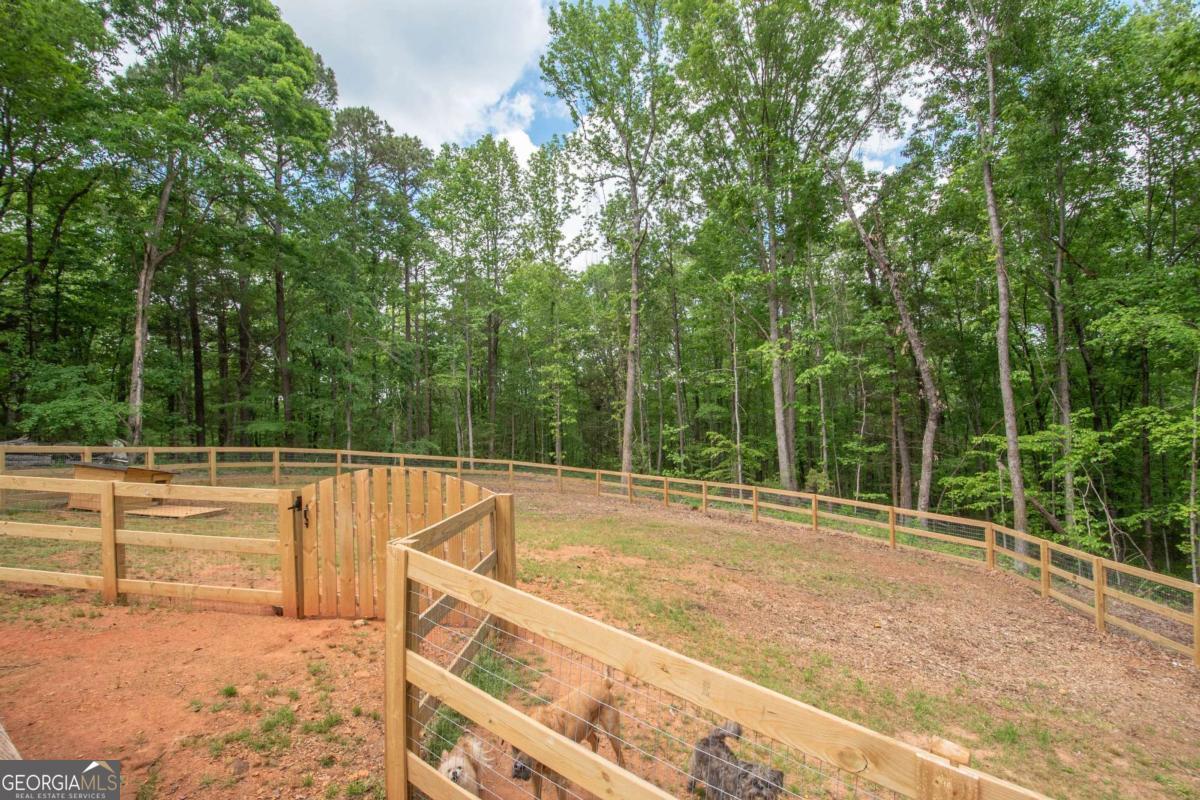 3414 Rock Mills Road LaGrange, GA 30240 - Photo 34 of 54 a view of a swimming pool with an outdoor seating and a forest