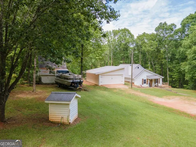 an aerial view of residential house with outdoor space and trees all around