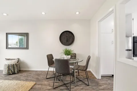 a dining room with furniture and wooden floor