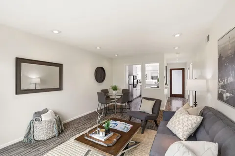 a living room with furniture and wooden floor