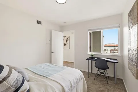 a bedroom with a bed a chair and a window
