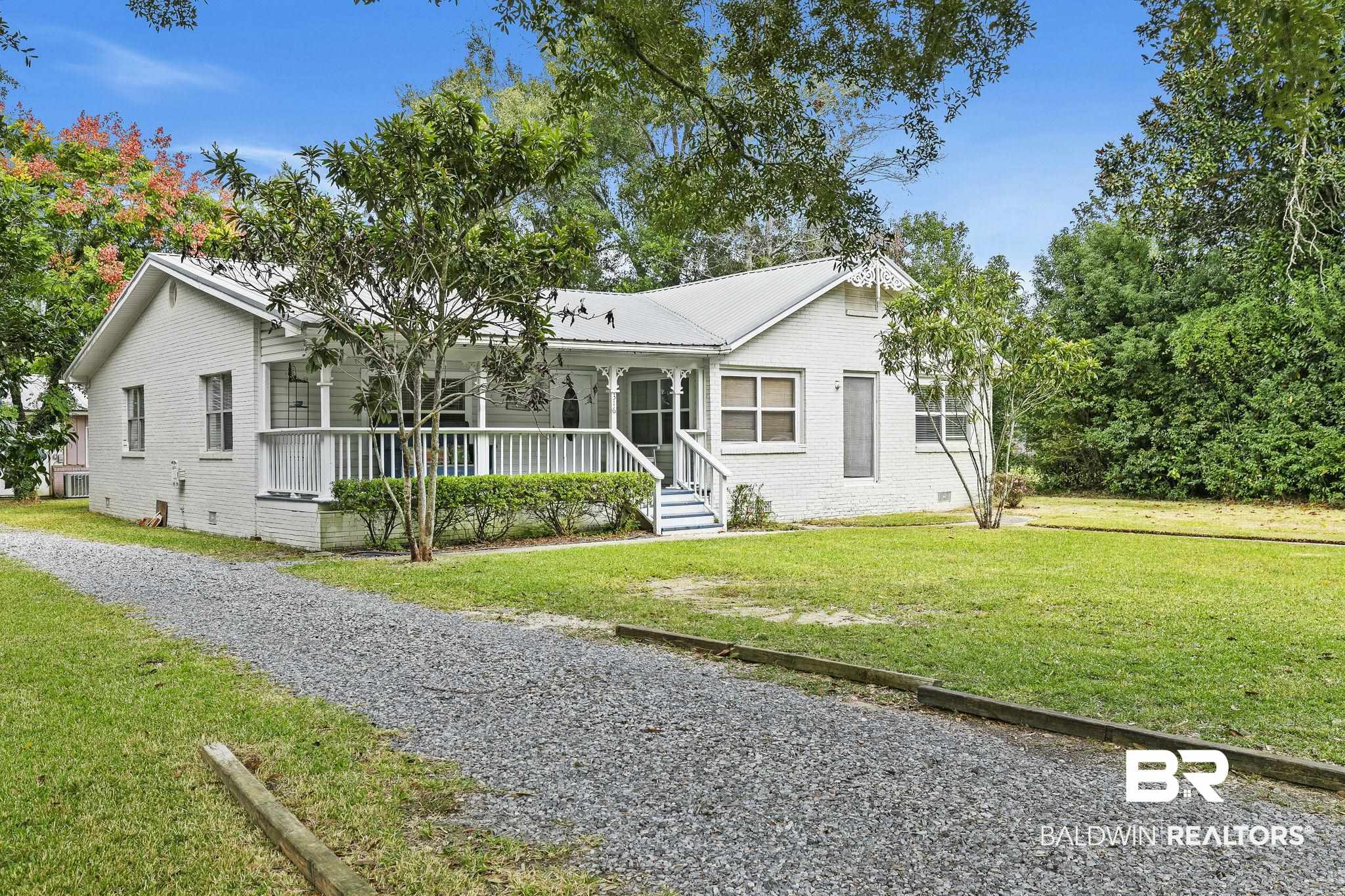 316 West Orchid Avenue Foley, AL 36535 - Photo 4 of 38 View of front of home with a porch, crawl space, brick siding, a front lawn, and a metal roof