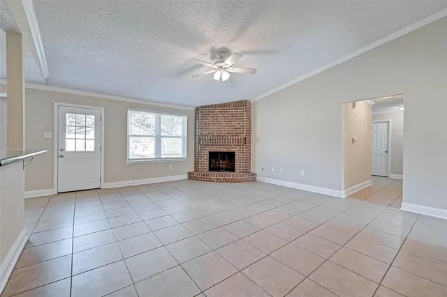 an empty room with windows and fireplace
