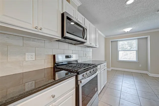 a kitchen with stainless steel appliances granite countertop a sink a stove a microwave and cabinets