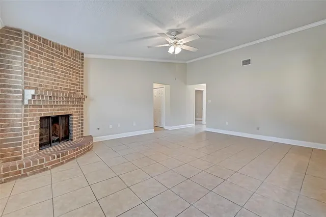 a view of an empty room with chandelier fan