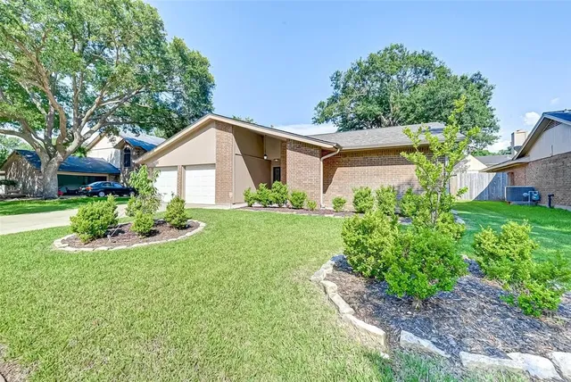 a front view of a house with a yard and trees