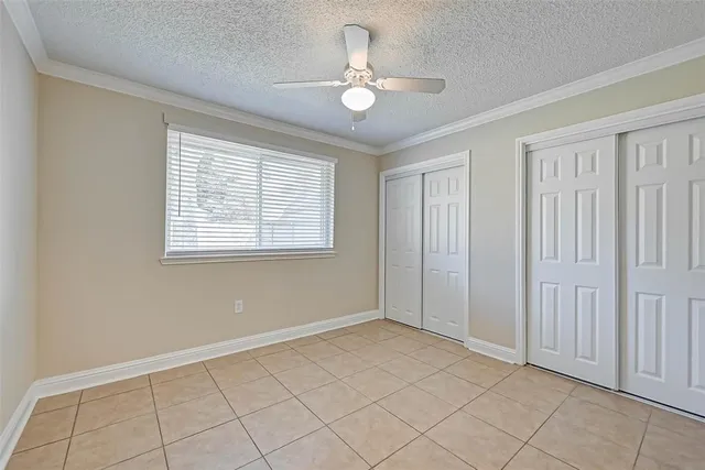 a view of an empty room with window chandelier fan