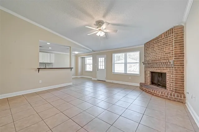 a view of an empty room with a fireplace and a window