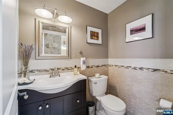 a bathroom with a sink mirror vanity and toilet