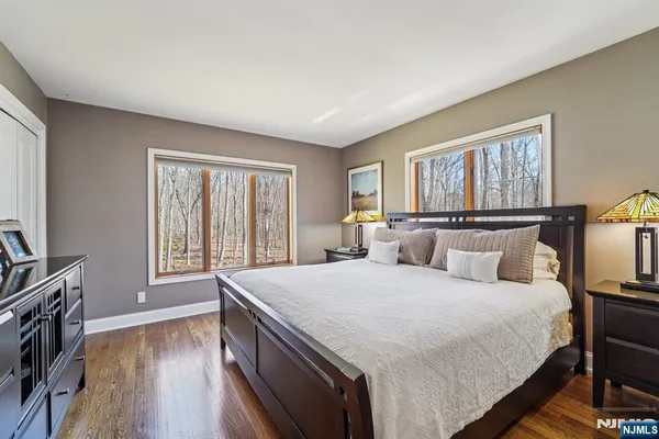 a large bedroom with a bed and wooden floor