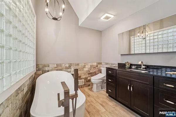 a bathroom with a toilet a sink and mirror