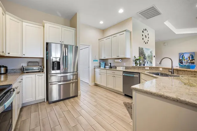 a kitchen with a refrigerator sink and cabinets
