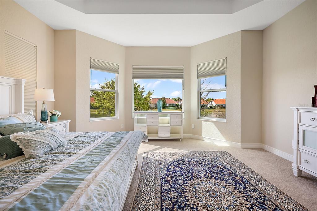 5129 Jared's Landing Way Oxford, FL 34484 - Photo 20 of 41 a large bedroom with a bed and glass door