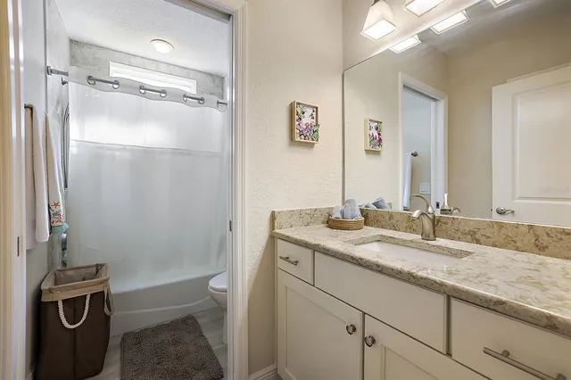 a bathroom with a granite countertop sink toilet and shower