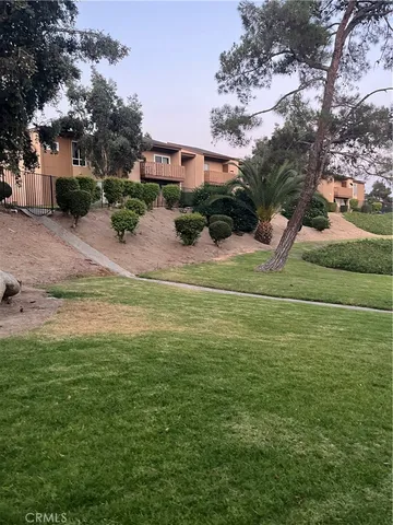 a view of a house with a big yard and large trees