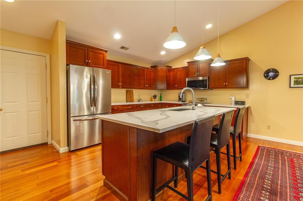 138 Abbey Road New Castle, PA 16105 - Photo 12 of 36 a kitchen with stainless steel appliances granite countertop a refrigerator a sink a stove and a refrigerator with wooden floor
