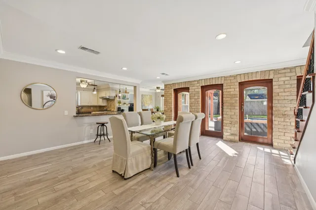 a kitchen with stainless steel appliances granite countertop a dining table chairs and white cabinets