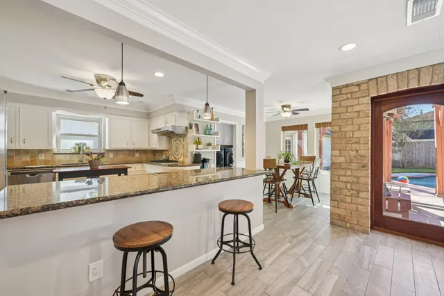 a kitchen with kitchen island granite countertop a sink a counter space and stainless steel appliances