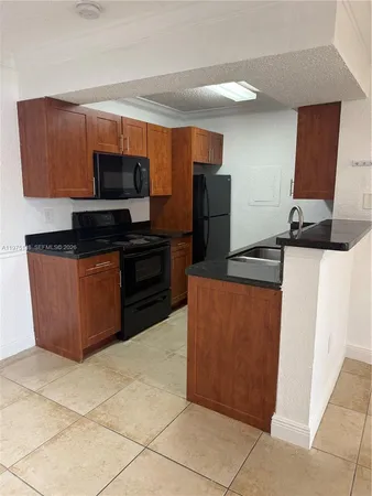 a kitchen with stainless steel appliances a refrigerator a sink a stove top oven and cabinets