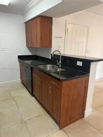 a kitchen with stainless steel appliances granite countertop a sink and a white cabinets